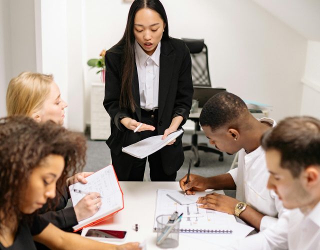 Colleagues engaged in a collaborative meeting in a modern office setting, discussing business plans.